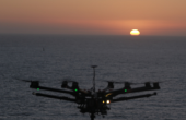 Drohne mit Blick auf den Ozean und die untergehende Sonne