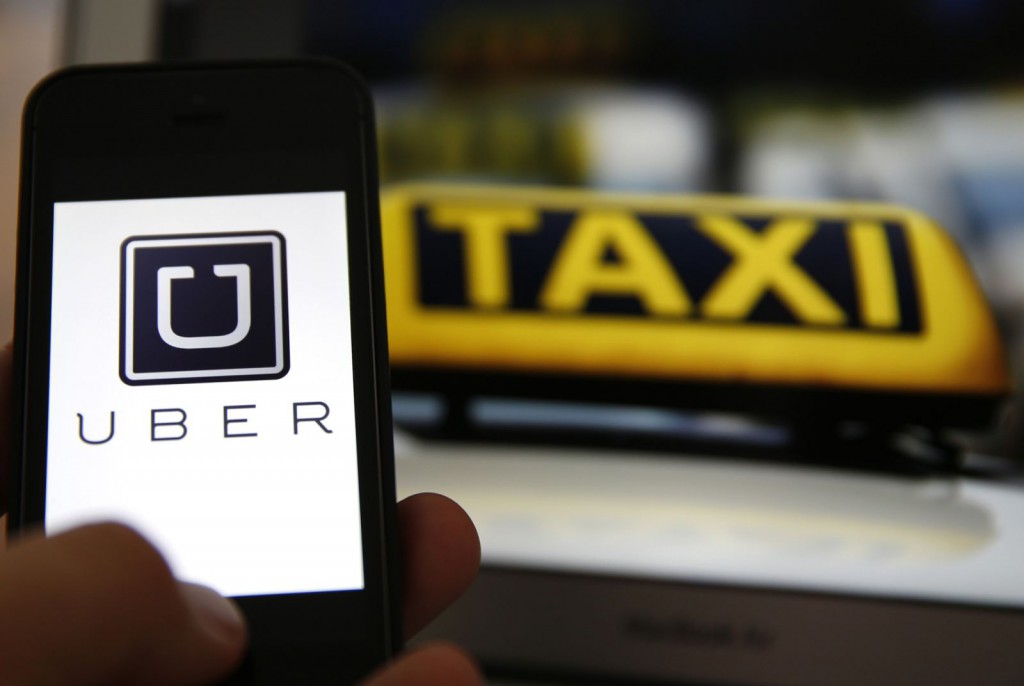 Uber-App, im Hintergrund ein Taxi-Schild