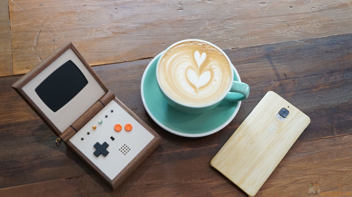 Pixel Vision auf einem Holztisch, daneben eine Tasse Kaffee und ein Smartphone